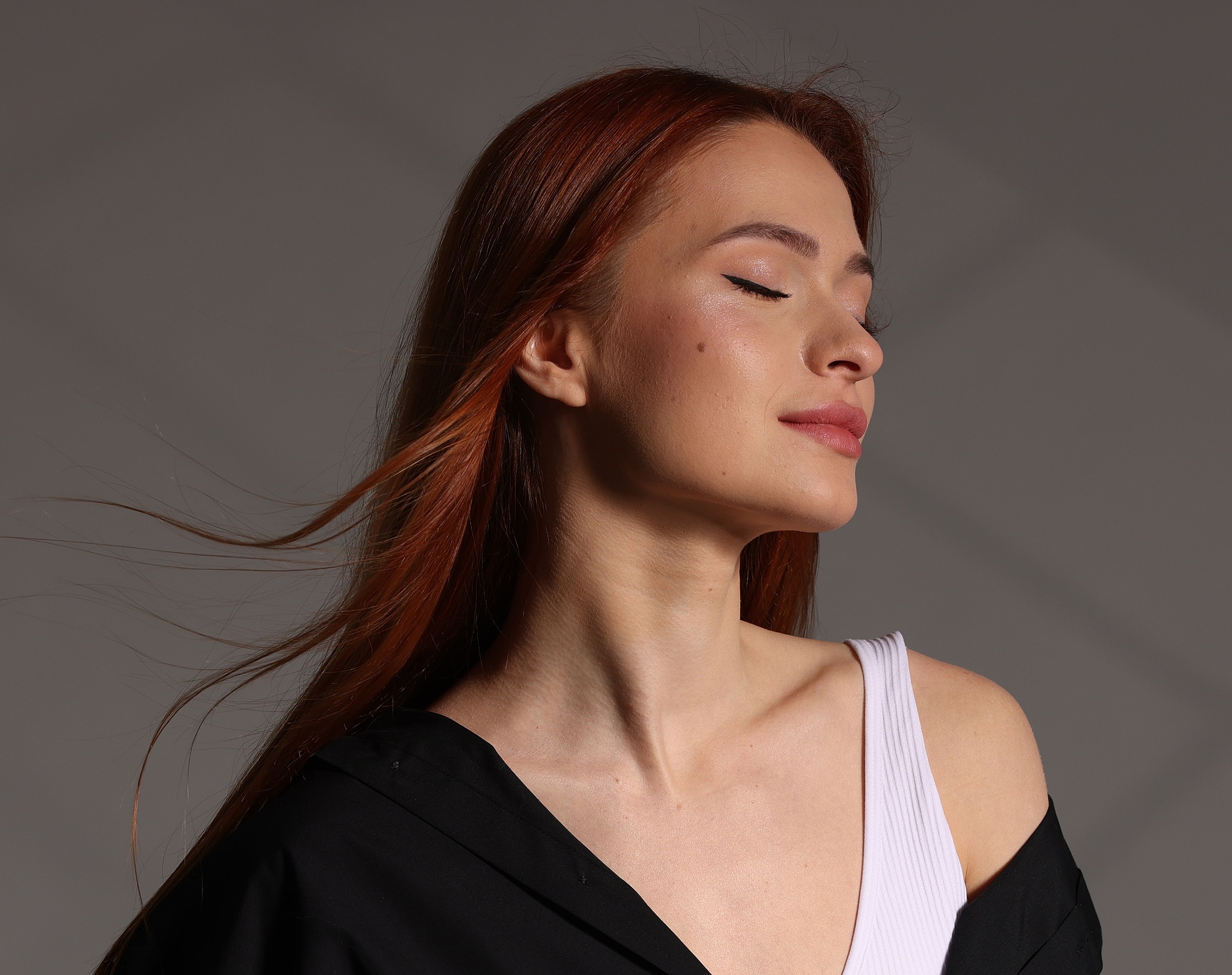 Woman with red hair and closed eyes.