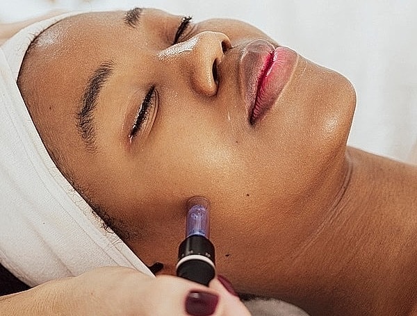 Facial treatment in progress on relaxed woman.